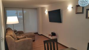 een woonkamer met 2 stoelen en een flatscreen-tv bij Concón, depto "Costa Borgoño" frente a playa La Boca in Concón