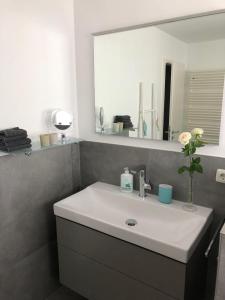 a bathroom with a white sink and a mirror at Moderne Ferienwohnung direkt in Landsberg am Lech in Landsberg am Lech