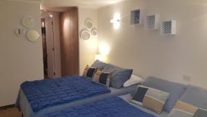 een slaapkamer met een blauw bed en een bank bij Concón, depto "Costa Borgoño" frente a playa La Boca in Concón +20 foto's