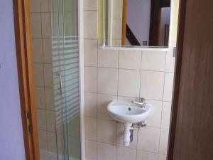 een badkamer met een wastafel en een spiegel bij LA MAISON FLEURIE Gîtes du Florimont in Ingersheim