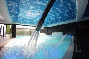 
a large swimming pool with a blue sky at Hotel & Thalasso Villa Antilla - Habitaciones con Terraza - Thalasso incluida in Orio
