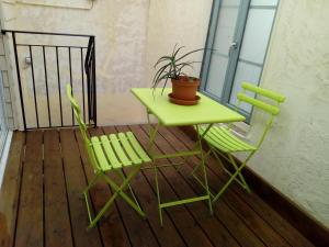 einen grünen Tisch und zwei Stühle auf dem Balkon in der Unterkunft Chambre indépendante à Carcassonne in Carcassonne