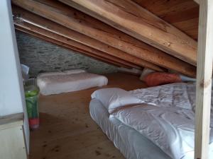 a attic room with two beds and wooden ceilings at La vera casa di Mosè in Marmora