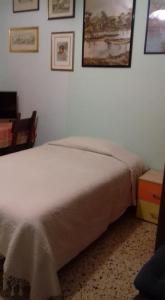a bedroom with a white bed and pictures on the wall at A casa di Alice in Rome +9 photos