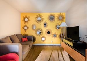 a living room with a couch and a wall with sun mirrors at Santa Rosa in Les Issambres