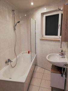 La salle de bains est pourvue d'une douche, d'une baignoire et d'un lavabo. dans l'établissement Marbacher Hof 1, à Hirschberg an der Bergstraße