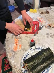 a person using a grater on a table with a plate of food at Dos Guesthouse in Bishkek