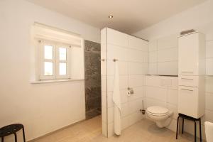 La salle de bains blanche est pourvue de toilettes et d'une fenêtre. dans l'établissement Archontiko Kourkoulos, à Makrádes