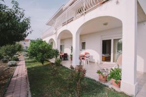 una vista exterior de una casa blanca con jardín en Apartments Jasna, en Podstrana