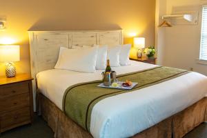 una camera con un grande letto e una bottiglia di vino di Pilgrim House a Provincetown