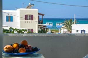 a bowl of fruit on a table with two glasses of wine at Sunday Studios in Agia Anna Naxos
