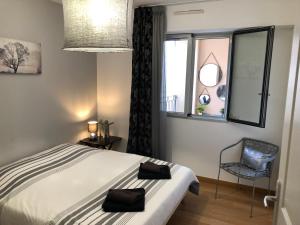 1 dormitorio con 1 cama, 1 silla y 1 ventana en 10 Rue de la Rampe, en Cannes