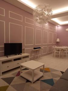 - un salon avec une télévision et une table dans l'établissement SKY PURPLE @CH, à Tanah Rata