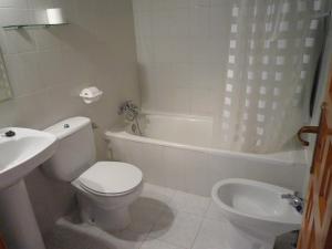 a bathroom with a toilet and a tub and a sink at Casa Rural El Molino de Alocén in Alocén +52 photos