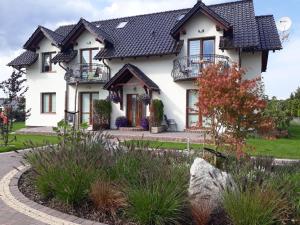 a white house with a black roof at Apartamenty Bursztynowe in Dębki