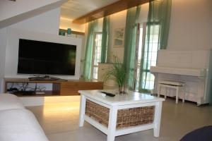 a living room with a couch and a tv and a piano at Villa Torre San Giovanni Ugento in Torre San Giovanni Ugento