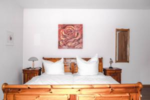 a bedroom with a wooden bed and a painting on the wall at Gasthof zur Alten Post-Pension in Fürstenzell