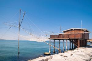 a building on a pier next to the water at Hotel Pineta in Sottomarina