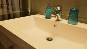 a bathroom sink with a blue soap dispenser on it at Apartment Giotto Eremitani in Padova
