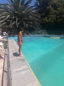 a man standing next to a swimming pool at Hosteria Pastoral & Spa in La Cumbre