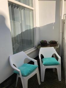 two white chairs sitting next to a window at BenSan Beach House Zandvoort with Private Parking in Zandvoort
