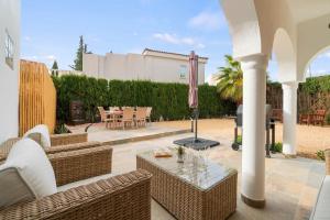 un patio al aire libre con muebles de mimbre y parrilla en Ashanti Garden Luxury Short Term Rental Duplex Altea, en La Nucía