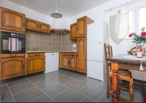 - une cuisine avec des placards en bois et un réfrigérateur blanc dans l'établissement La petite maison, à La Gaude