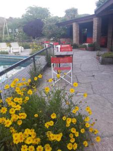 un jardín con flores amarillas junto a una valla en Hosteria Pastoral & Spa en La Cumbre