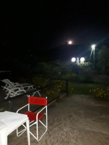 una silla roja sentada junto a una mesa por la noche en Hosteria Pastoral & Spa en La Cumbre