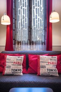 a couch with two red pillows in front of a curtain at Terrazzina - Romantic Pied A Terre at the heart of Cannaregio district in Venice