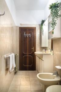 a bathroom with a toilet sink and a brown door at Terrazzina - Romantic Pied A Terre at the heart of Cannaregio district in Venice