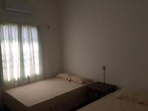 1 Schlafzimmer mit 2 Betten und einem Fenster in der Unterkunft Hostal La Concordia in Ciudad Valles