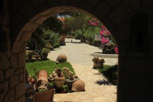 an archway in a garden with potted plants and flowers at Irides in Souvala