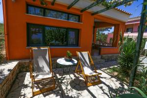 two chairs and a table in front of a house at Irides in Souvala