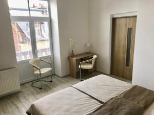 a bedroom with a bed and a desk and two chairs at Apartmány Dagmar in Mariánské Lázně