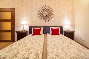 a bedroom with a large bed with red pillows at Chocolate Apartment in Sibiu