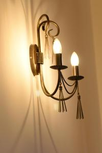 a brass light fixture hanging on a wall at Chocolate Apartment in Sibiu