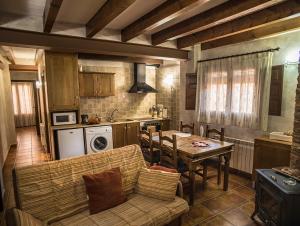 a kitchen with a couch and a table in a room at Cases Rurals El Castell in Torres-Torres