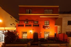 a building with an orange hue at night at Casa Suyay in Lima