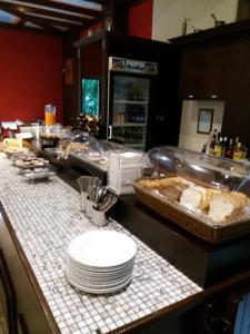 una línea de buffet con platos blancos en un mostrador en Spanias Hotel en Kalabaka