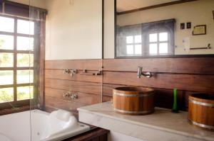 a bathroom with two large wooden barrels on a counter at Hotel Porto do Zimbo in Morro de São Paulo