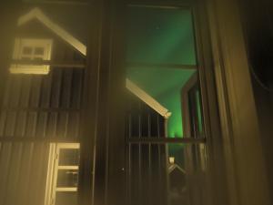 a view of a green light through a window at Hlid Fisherman's Village in Álftanes
