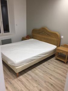 a bed in a room with a white mattress at La cathare appartement in Lézignan-Corbières