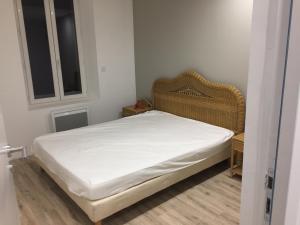 a small bedroom with a bed with white sheets at La cathare appartement in Lézignan-Corbières +2 photos