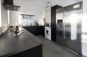 a kitchen with a refrigerator and a washing machine at Hellatún Guest House! in Hella