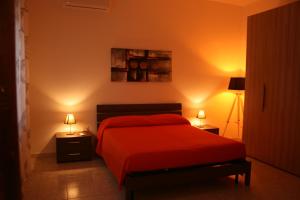 a bedroom with a red bed and two lamps at La casa dei nonni in Iglesias