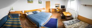 a bedroom with a blue bed and a living room at Penzión Marco Polo in Vrútky