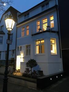 ein weißes Gebäude mit Straßenbeleuchtung davor in der Unterkunft Privatzimmer Schönfelder in Düsseldorf