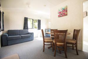 a living room with a couch and a table and chairs at Stratford Motel & Holiday Park in Stratford