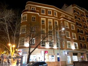 un bâtiment dans une rue de la ville la nuit dans l'établissement Hotel Bienvenidos Rooms Xàtiva, à Xàtiva